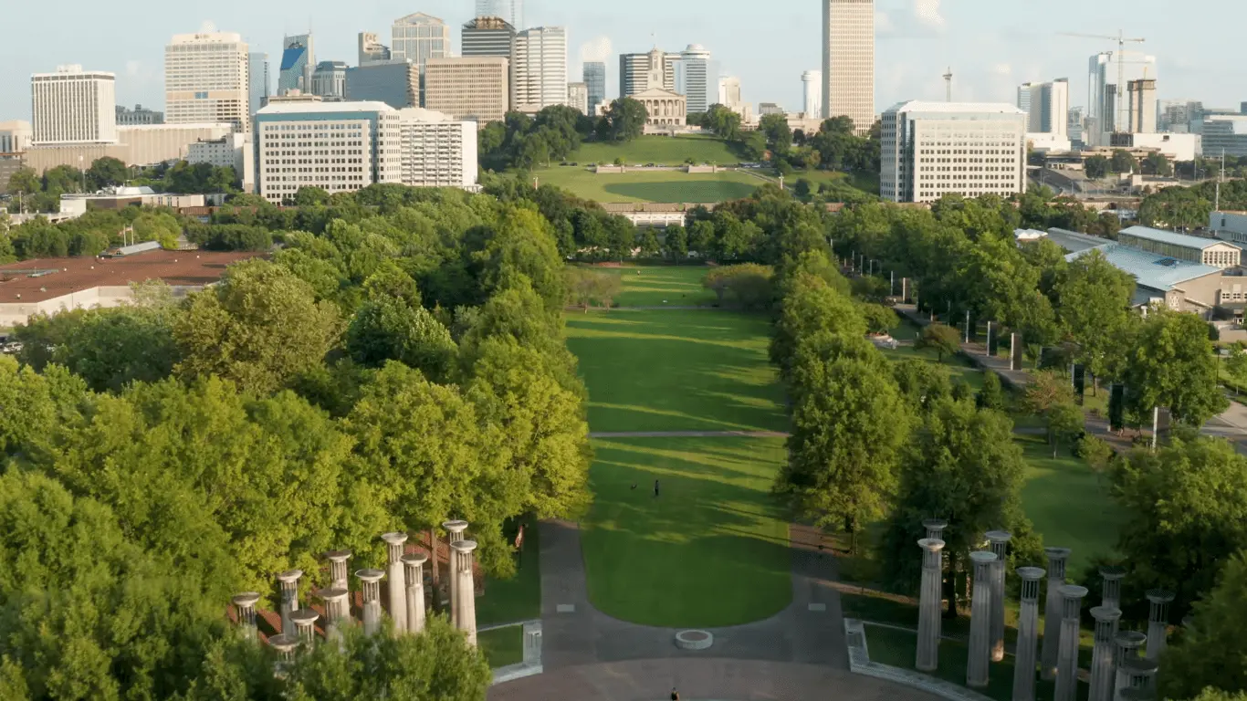 Nashville skyline rises above Bicentennial Capitol Mall State Park, where green spaces meet historic stone column