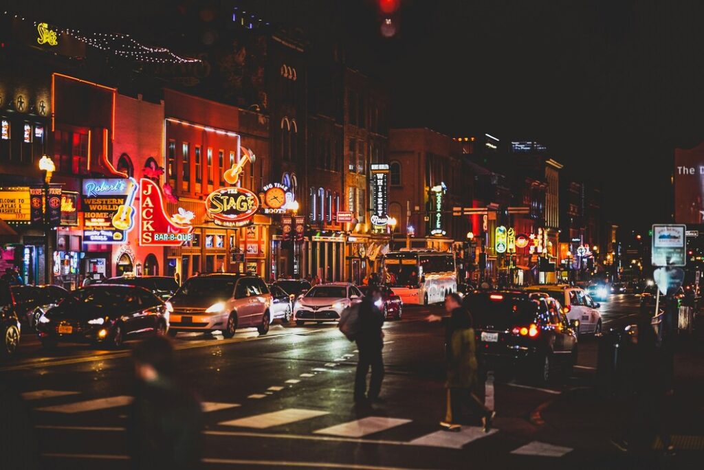 Busy Broadway Street in Nashville with neon lights, live music venues, and crowds enjoying the vibrant nightlife