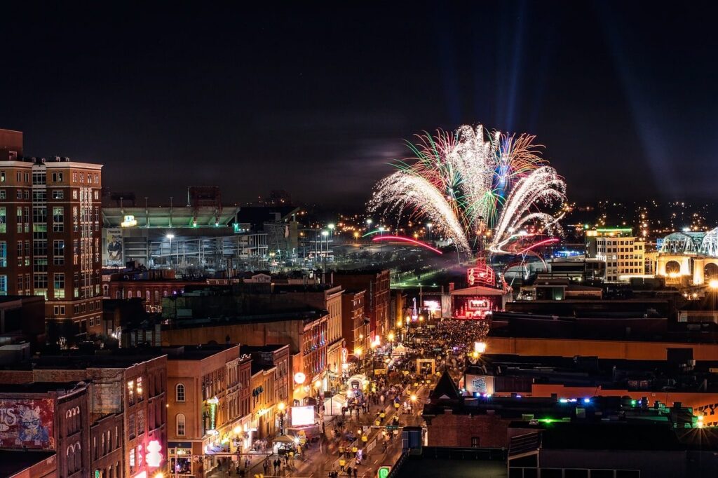 Aerial view of Nashville's Tennessee Broadway street during fireworks celebration with illuminated buildings and crowded streets