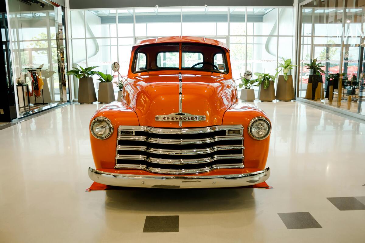 Pristine vintage orange Chevy truck displayed in Nashville museum, showcasing the city's classic American automotive history.