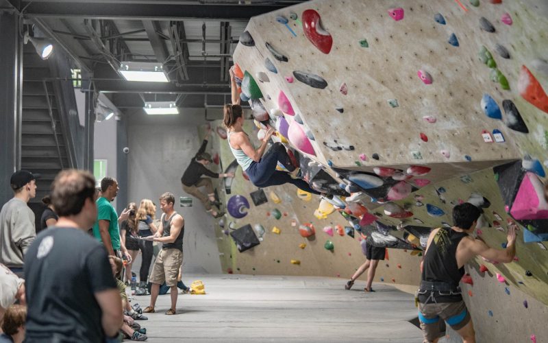 Climbers scaling colorful walls at Nashville's indoor rock gym, ropes secured for safe ascents