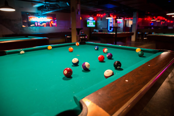 Pool table in a dimly-lit Nashville bar, cues chalked and ready for a late-night game