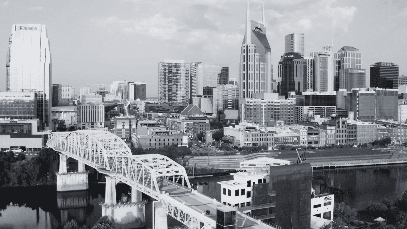 skyline view of Nashville showing historic architecture, iconic bridge spanning Cumberland River representing Tennessee's cultural heritage