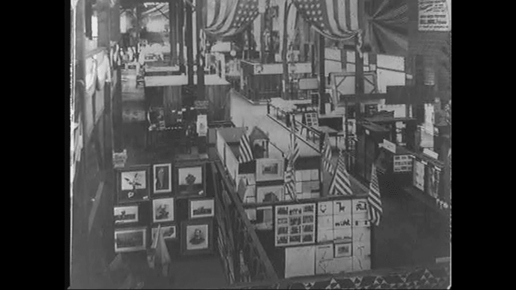 Historic black and white interior photograph of the Nashville Parthenon when it first opened as a city museum in 1931, showing the gallery space with artwork displayed on walls, American flags, and visitors walking through the exhibition area