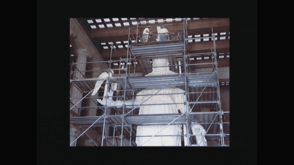 Construction work on the Athena statue inside Nashville's Parthenon during its restoration, showing craftsmen on scaffolding carefully working on the massive white sculpture that would become the centerpiece of the building's interior