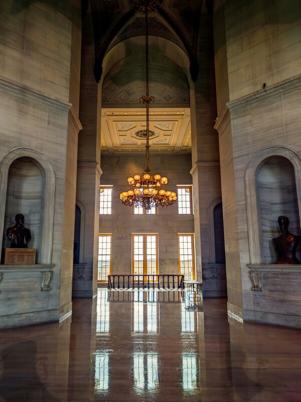 Interior hallway of Tennessee State Capitol showing high vaulted ceiling, elegant chandelier and classical architectural details