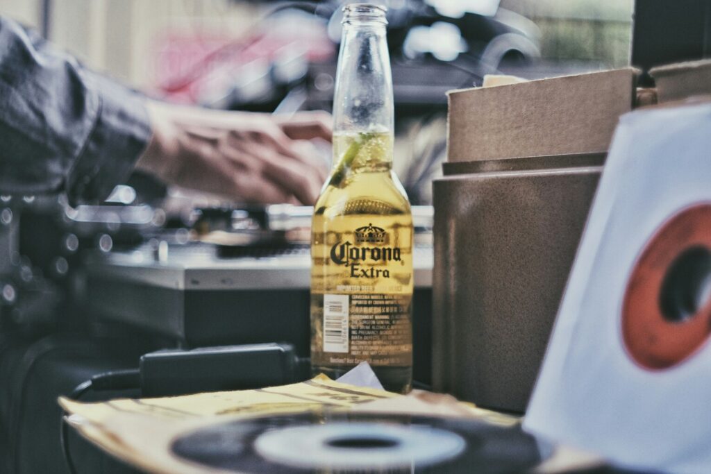 Corona beer bottle next to vinyl records and audio equipment in a Nashville record shop at Nashville