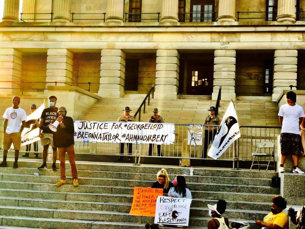 Protesters with sign boards advocating for justice gather on the steps of Tennessee State Capitol building