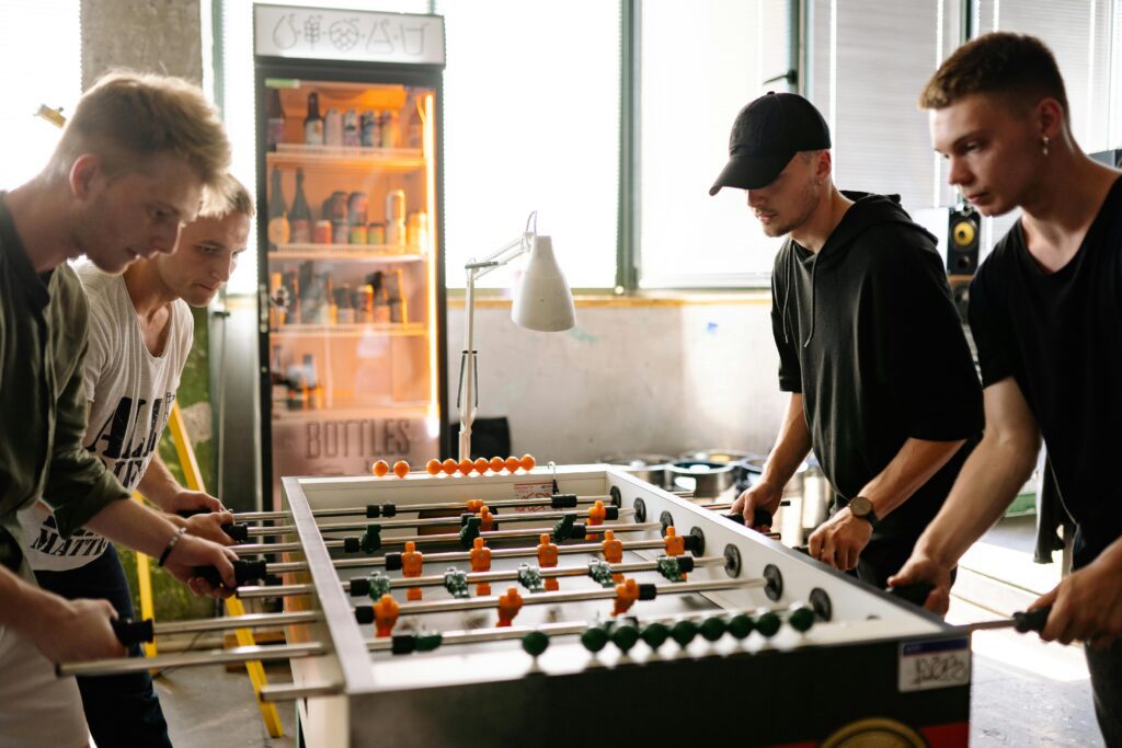 Vintage foosball table in a Nashville pub, players spinning rods for a winning goal