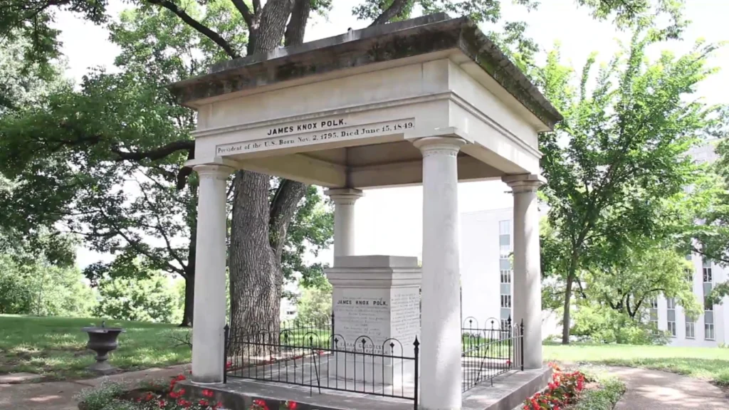 James K. Polk memorial tomb with white columns on Tennessee State Capitol grounds surrounded by trees