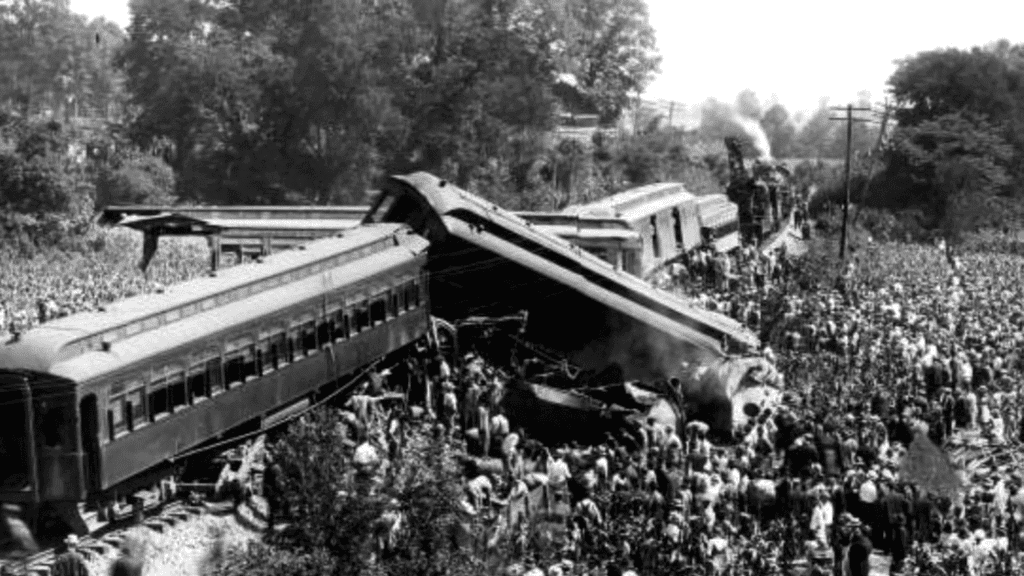 Historic black and white photograph of the 1918 train wreck at Dutchman's Curve with damaged train cars and crowd