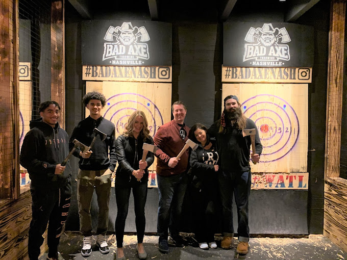 Throwing axes at wooden targets in Nashville's rugged indoor arena—safety goggles on