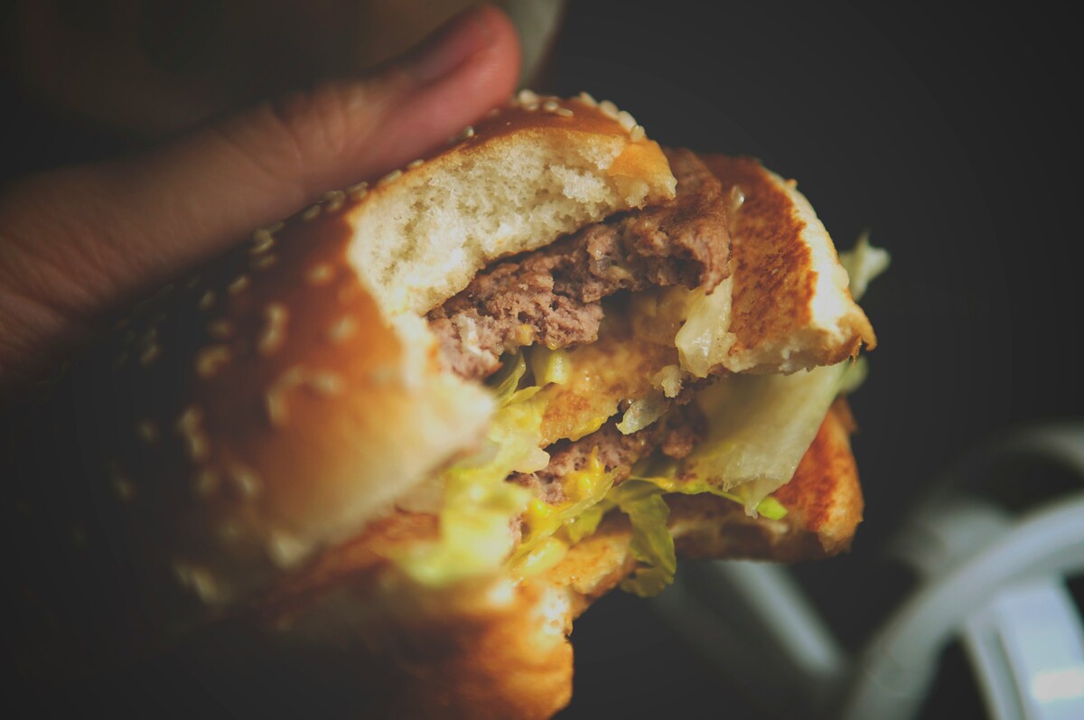 Loaded cheeseburger cross-section revealing juicy patty and toppings from casual locals loved in East Nashville restaurants