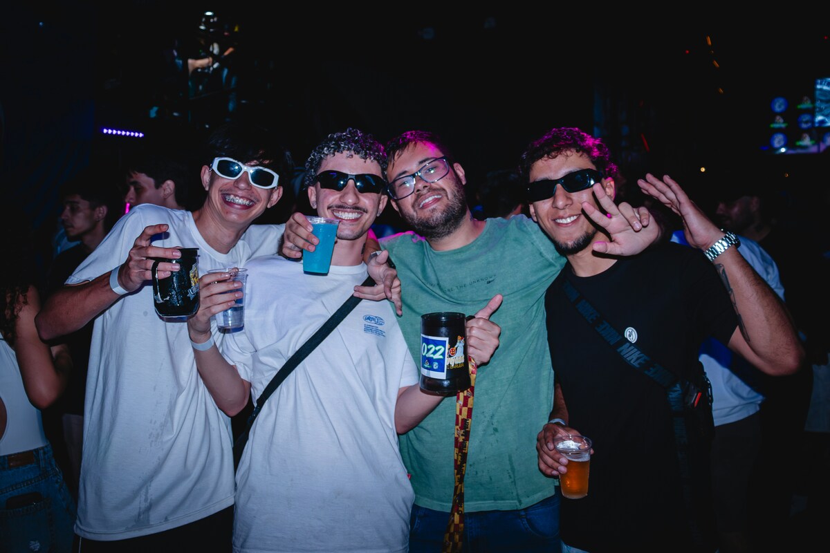 Friends celebrating Nashville nightlife with drinks and laughter under colorful club lights downtown
