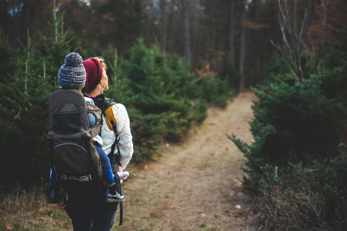 Outdoor Nashville fun hiking adventure with couple wearing backpacks walking on forest trail surrounded by trees