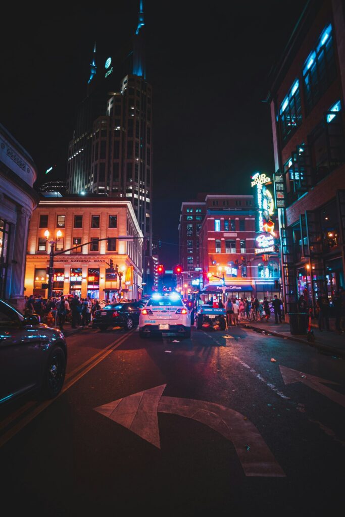 Police presence in downtown Nashville at night, showing visible safety measures amid vibrant, bustling nightlife scene
