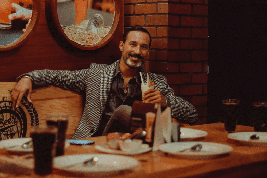 Me smiling in my houndstooth blazer while enjoying drinks and the great atmosphere at one of the best East Nashville restaurants