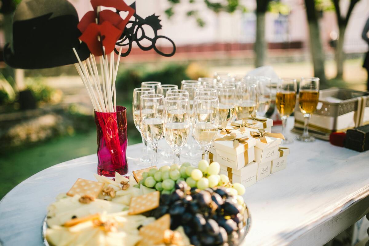 Outdoor Nashville food celebration with champagne glasses, cheese board, and party props on elegant white table setup