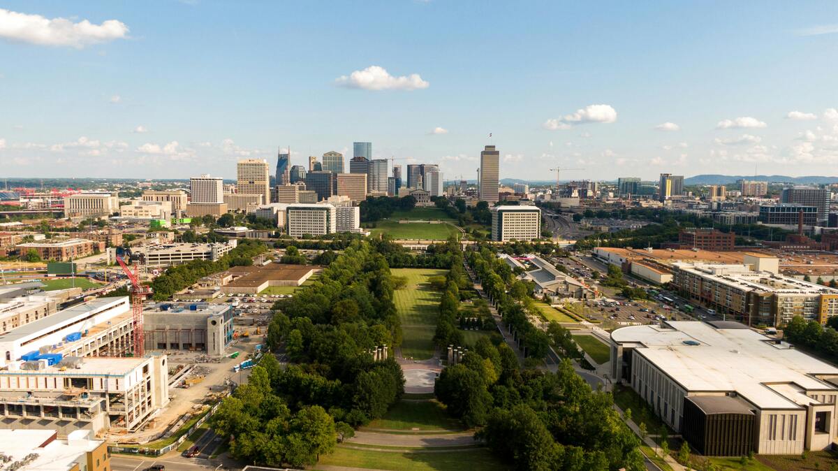 :
Outdoor Nashville fun aerial view showcasing downtown skyline with green parks and modern buildings under blue sky