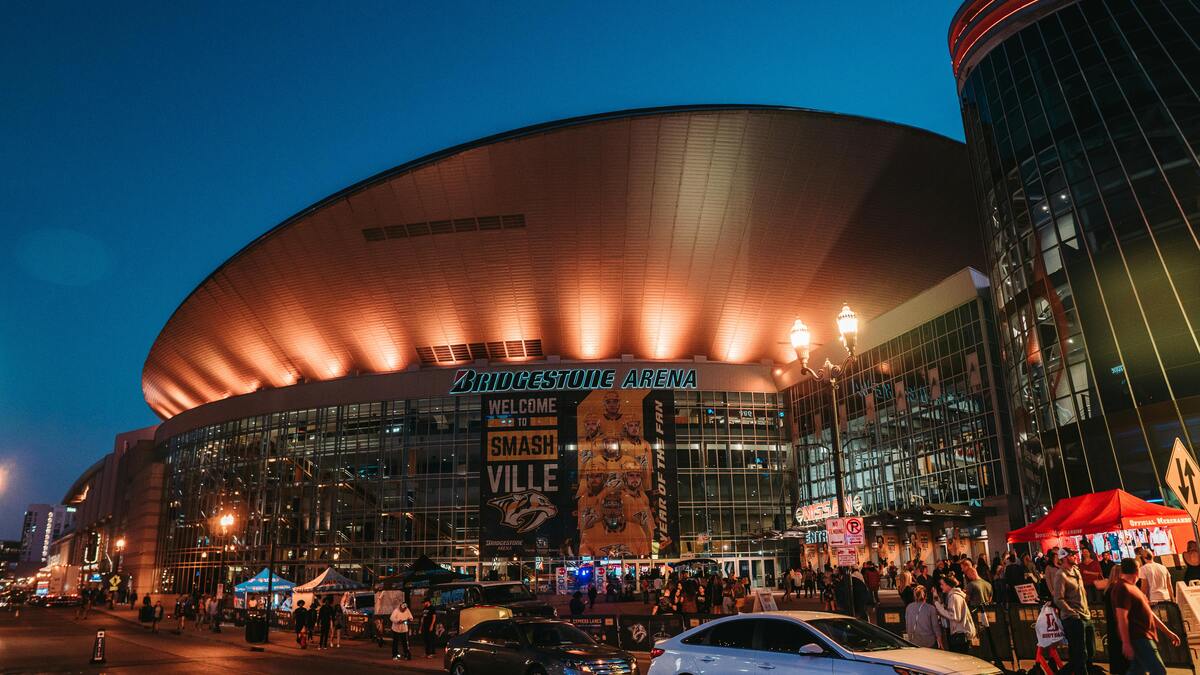 Bridgestone Arena lit up at night with crowds gathering for things to do in Nashville in November cma events