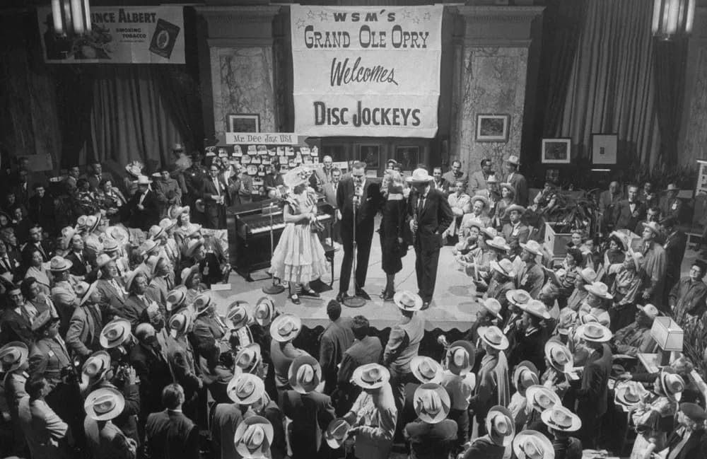Minnie Pearl performing at 1950s WSM Grand Ole Opry, a landmark in Nashville country music history and nickname origin.
